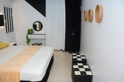 a bedroom with a bed and a black cat in the corner at T2 City Center in Mindelo
