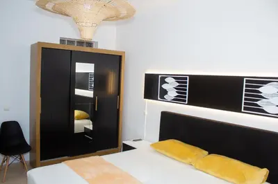 a bedroom with a black and white bed and a mirror at T2 City Center in Mindelo