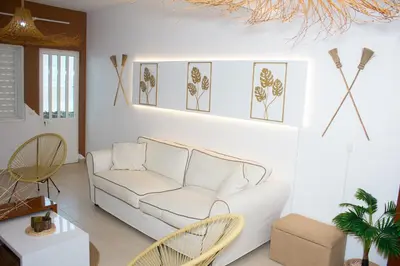 a living room with a white couch and chairs at T2 City Center in Mindelo