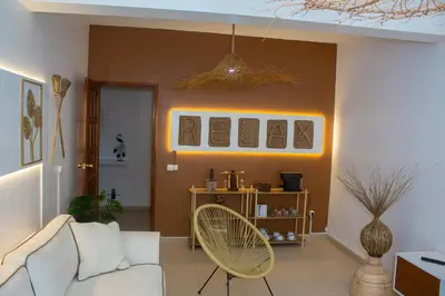 a living room with a white couch and a fan at T2 City Center in Mindelo