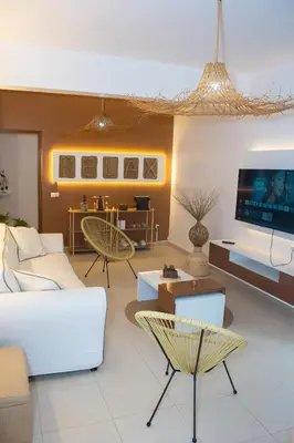 a living room with white furniture and a flat screen tv at T2 City Center in Mindelo