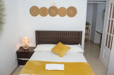 a bedroom with a bed with a wooden head board at Morabeza T2 City Center in Mindelo
