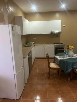 a kitchen with a table and a white refrigerator at Home Lenda in Tarrafal