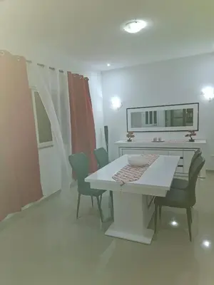 a dining room with a white table and chairs at Casa Melissa in Ponta do Sol