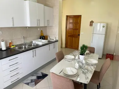 a kitchen with a table with chairs and a sink at Lovely comfortable apartment in Praia in Praia