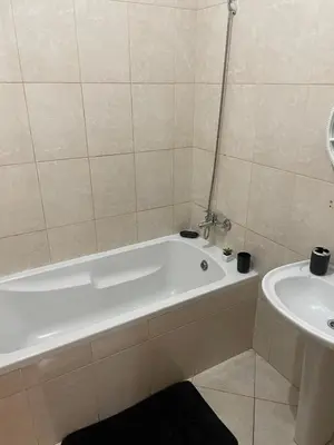 a bathroom with a white bath tub next to a sink at Lovely comfortable apartment in Praia in Praia