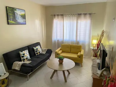a living room with a couch and a chair and a table at Lovely comfortable apartment in Praia in Praia