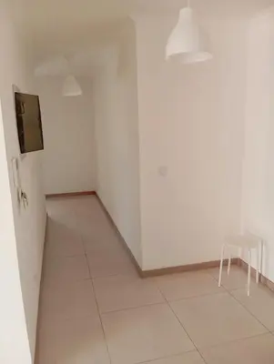 a white room with a chair and a refrigerator at Apt T2 -Laginha -On The Beach in Mindelo