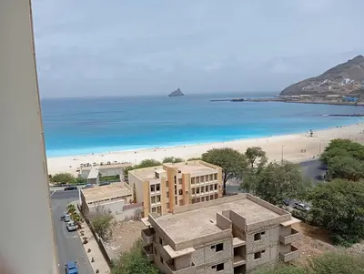 a view of a beach with a building and the ocean at Apt T2 -Laginha -On The Beach in Mindelo