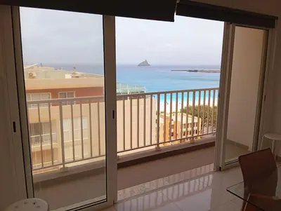 a room with a balcony with a view of the ocean at Apt T2 -Laginha -On The Beach in Mindelo