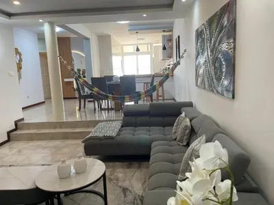 a living room with a couch and a table at Hendy's cozy apt in Praia