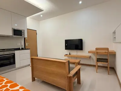 a kitchen with a couch and a tv on the wall at FreLux Urban Studio in Praia