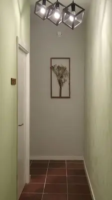 a hallway with a wall with a picture of a tree at Djeu Guest House in Santa Maria