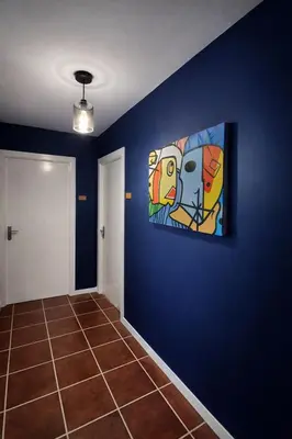 a room with a painting on a blue wall at Djeu Guest House in Santa Maria