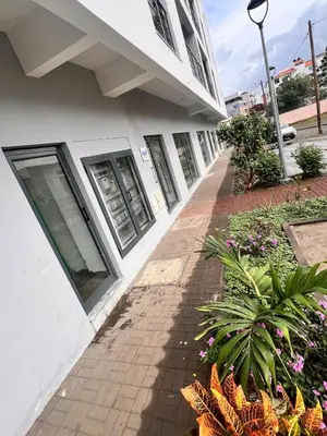 a sidewalk in front of a building with flowers at Bright Modern Apart Mountain View, 5 Min to Beach in Praia