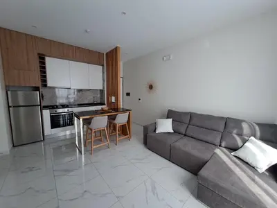 a living room with a couch and a table and a kitchen at Ocean Spirit Mindelo Apartment in Mindelo