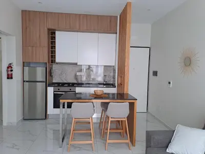a kitchen with a table and two stools at Ocean Spirit Mindelo Apartment in Mindelo