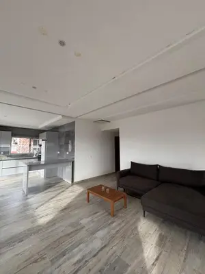 a living room with a black couch and a table at Caetana e Ferro in Calheta
