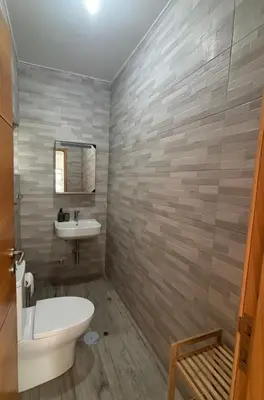 a bathroom with a white toilet and a sink at Caetana e Ferro in Calheta