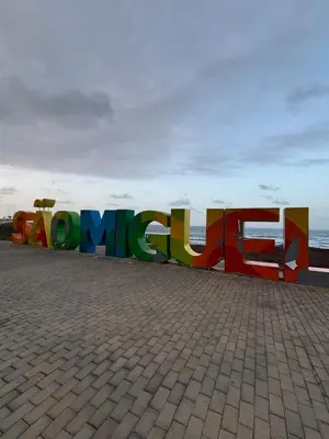 a large sign that says huguez in front of the ocean at Caetana e Ferro in Calheta