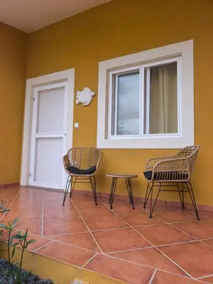 two chairs and a table in front of a door at Maio Sweet Tartaruga in Vila do Maio