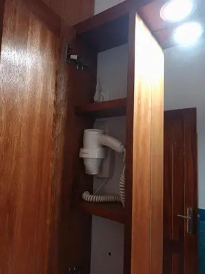a bathroom with a toilet in a wooden cabinet at Maio Sweet Tartaruga in Vila do Maio