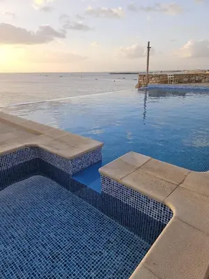 a swimming pool with a view of the ocean at Maio Sweet Tartaruga in Vila do Maio