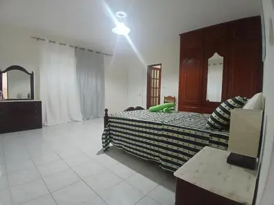 a bedroom with a bed with a dresser and a mirror at ROMANA guest house in Tarrafal da Vila de Ribeira Grande