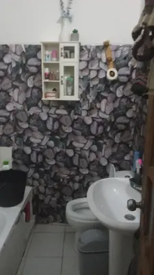 a bathroom with a stone wall with a toilet and a sink at AnaSpace in Praia