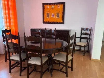 a dining room table with chairs and a painting on the wall at Casa Fernandes in Praia