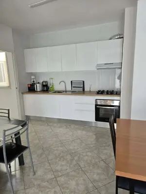 a kitchen with white cabinets and a table and a dining room at Golden Flow in Espargos