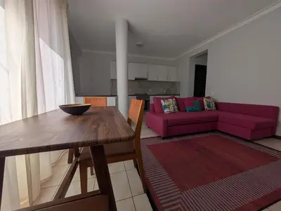 a living room with a table and a pink couch at Apartamento Espargos in Espargos