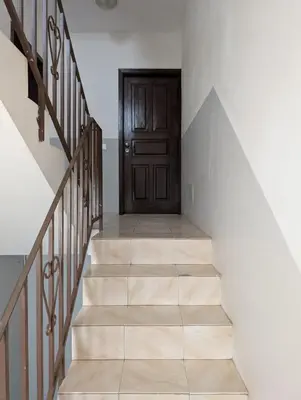 a hallway with a wooden door and stairs at Apartamento Espargos in Espargos