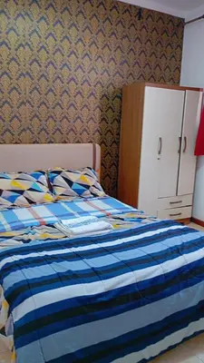 a bedroom with a bed with a blue blanket and a cabinet at Topklass homes in Praia