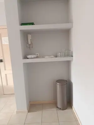 a trash can in a room with white walls at Pires's House in Mindelo