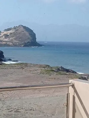 a view of the ocean with a mountain in the background at Sol Lazareto Mindelo in Prainha