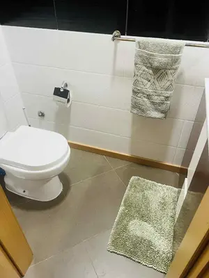 a bathroom with a toilet and towels on the wall at Apartamento Vieira in Santa Maria