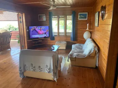 a living room with a tv and a couch and chairs at Casa TROPIKAL Maio Ponta Preta in Vila do Maio