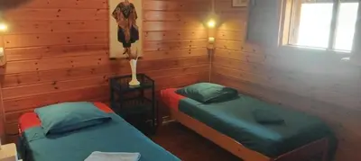 two twin beds in a room with wooden walls at Casa TROPIKAL Maio Ponta Preta in Vila do Maio