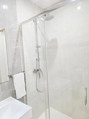 a shower with a glass door next to a sink at Feeling Santa Maria in Santa Maria