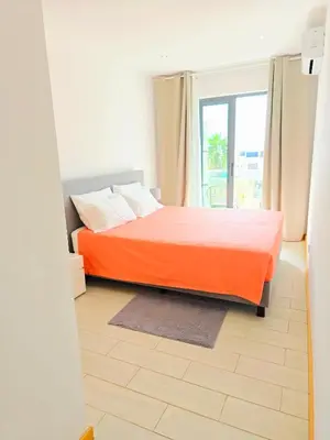 a bedroom with an orange bed and a window at Feeling Santa Maria in Santa Maria
