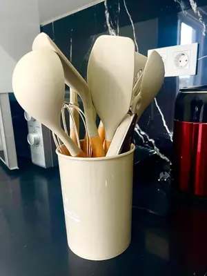 a container filled with utensils sitting on a counter at Encanto do Mar in Santa Maria