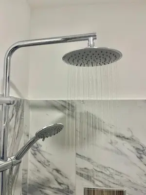 a shower with a shower head in a bathroom at Encanto do Mar in Santa Maria