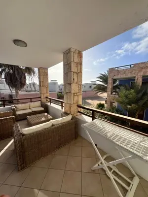 a balcony with wicker chairs and a table on a roof at Ca' Zen in Sal Rei