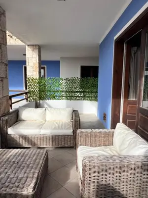 a living room with wicker furniture and a blue wall at Ca' Zen in Sal Rei