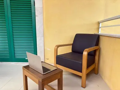a chair and a laptop sitting on a table next to a building at Realeza in Santa Maria