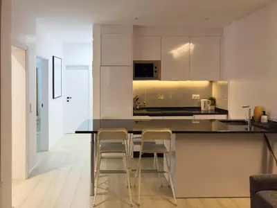 a kitchen with white cabinets and a black counter top at 2 bdr aprt, stunning view, rooftop pool - LCGR in Praia