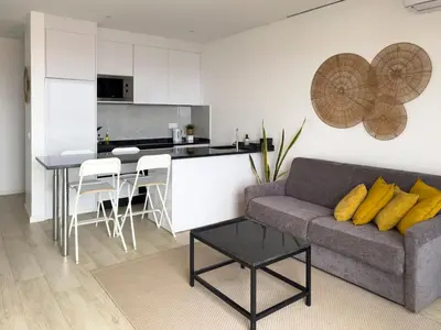 a living room with a couch and a kitchen at 2 bdr aprt, stunning view, rooftop pool - LCGR in Praia