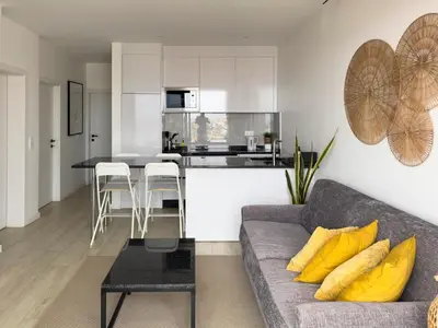 a living room with a couch and a kitchen at 2 bdr aprt, stunning view, rooftop pool - LCGR in Praia
