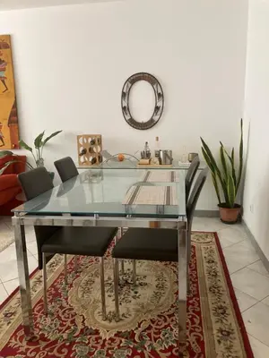 a glass dining room table with chairs and a mirror at AkyaSpot in Praia